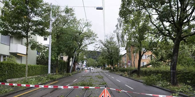 Umgestürzte Bäume und abgebrochene Äste behindern nach einem schweren Unwetter in Zürich am 13. Juli 2021 den Verkehr und das Durchkommen für Fussgänger. Kräftige Gewitter mit Starkregen, Hagelschlag und Sturmböen zogen im 2021 mehrfach über Teile der Schweiz. Wetter 2021