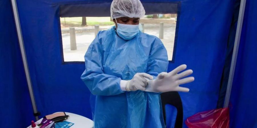 Ein Mitarbeiter des Gesundheitswesens in Südafrika bereitet sich auf einen Corona-Test vor. Foto: Denis Farrell/AP/dpa