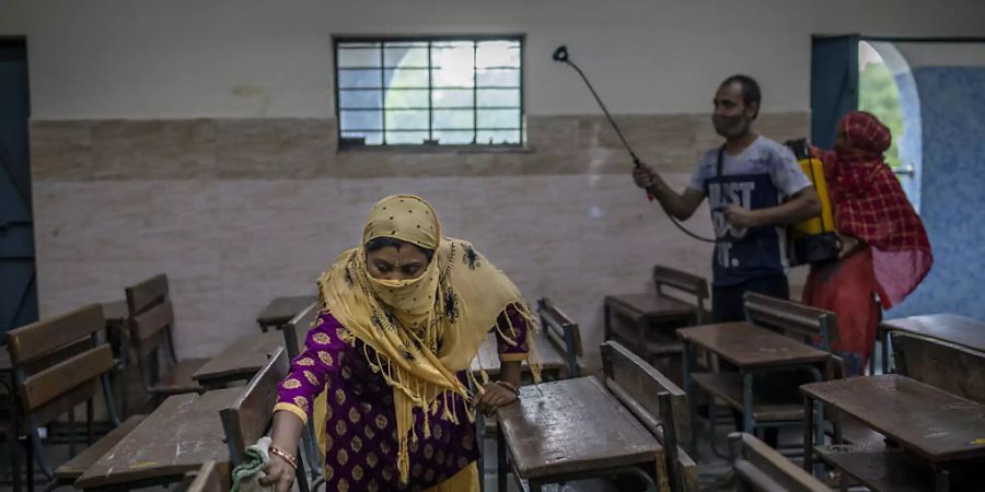 ARCHIV - In Neu Delhi wird ein Klassenzimmer desinfiziert. Foto: Altaf Qadri/AP/dpa