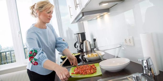 Was bekommt mir wann am besten? Ernährungspläne auf der Basis von DNA-Analysen sollen Antworten liefern. Frau kocht