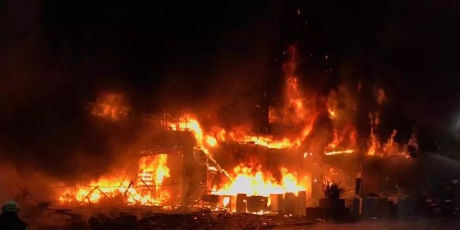 Flammen schlagen aus dem brennenden 13-stöckigen Geschäfts- und Wohngebäude in der Innenstadt. Foto: Fire Bureau Of Kaohsiun/ZUMA/dpa