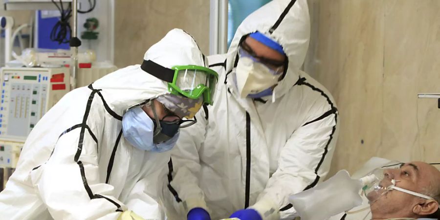 ARCHIV - Auf dem vom iranischen Gesundheitsministerium zur Verfügung gestellten Foto kümmern sich Mediziner um einen Covid-19-Patienten. Foto: Akbar Badrkhani/Iranian Health Ministry via AP/dpa