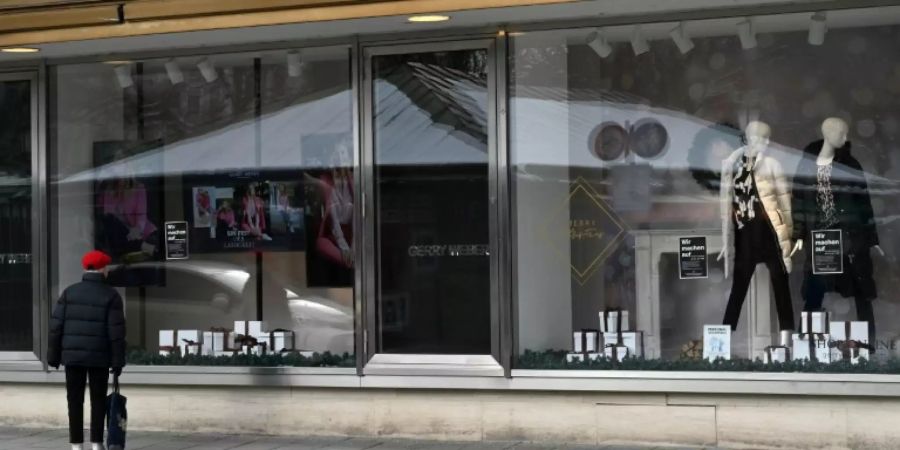 Passantin vor einem geschlossenen Geschäft in München