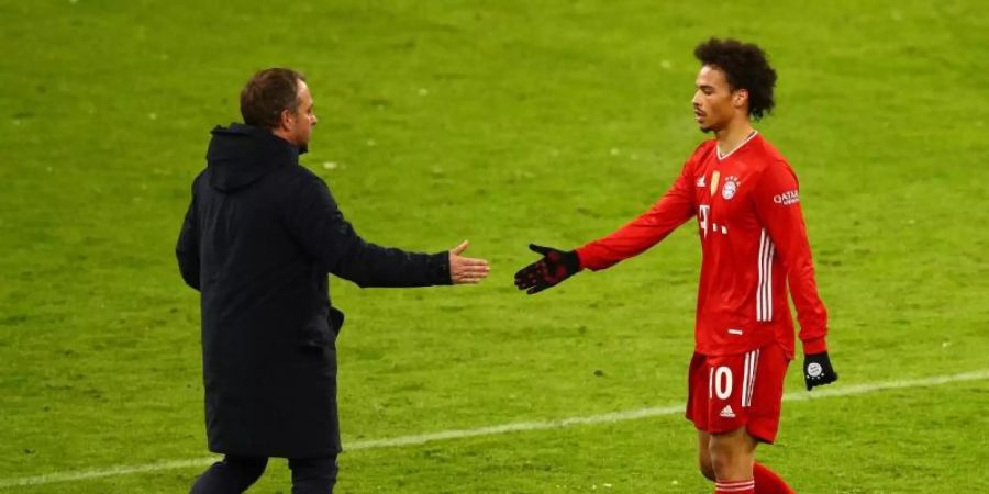 Hansi Flick (l) bedankt sich nach dem Spiel bei Leroy Sane. Foto: Adam Pretty/Getty Images Europe/Pool/dpa