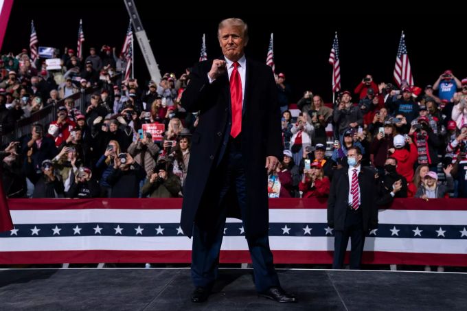 Donald Trump (M), Amtierender Präsident der USA, reckt kurz vor dem Verlassen der Bühne nach einer Wahlkampfkundgebung für die beiden republikanischen Senatskandidaten K. Loeffler und D.Perdue auf dem Regionalflughafen Valdosta die Faust. Trump-Auftritt