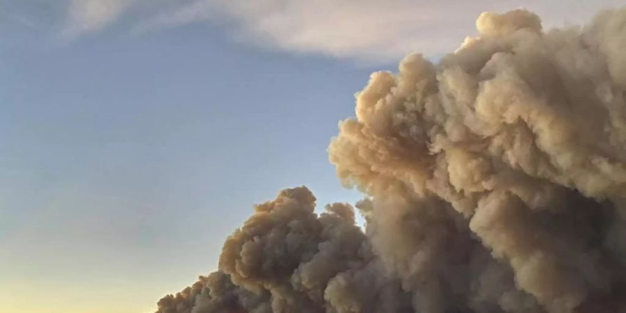 Hinter einem Bergkamm im Norden von Colorado steigen über dem Schein des Feuers die Rauchwolken auf. Foto: Jessy Ellenberger/AP/dpa