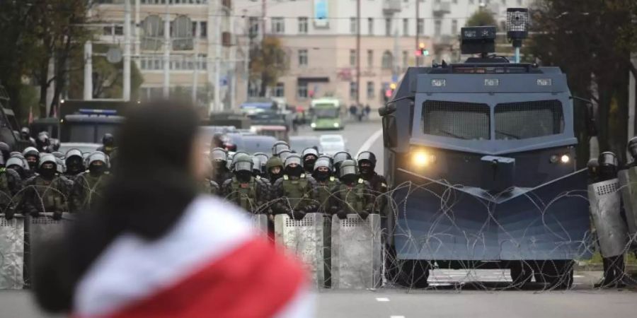 Ein Demonstrant steht in Minsk einer Reihe von Polizisten gegenüber. Foto: Uncredited/AP/dpa