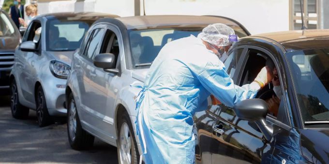 Ein medizinischer Mitarbeiter in Schutzkleidung nimmt einen Abstrich von einem Autofahrer für einen Covid-19-Test vor einem Gesundheitszentrum. (Symbolbild) Coronavirus - Italien