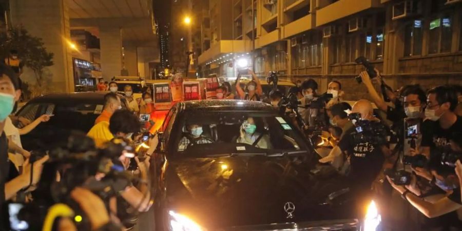 Jimmy Lai (Vordersitz, r) wird beim Verlassen des Polizeireviers von mehreren Dutzend Anhängern der Demokratiebewegung bejubelt. Foto: Kin Cheung/AP/dpa