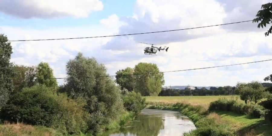 Ein Helikopter überfliegt die Unstrut. Feuerwehrleute suchen seit Sonntagmittag, 06.09.2020 am Flussufer der Unstrut bei Schönewerda (Kyffhäuserkreis) nach einem Krokodil, das eine Pferdebesitzerin gesichtet haben will. Der Landkreis sprach eine öffentliche Warnung aus. Foto: WichmannTV/dpa-Zentralbild/dpa