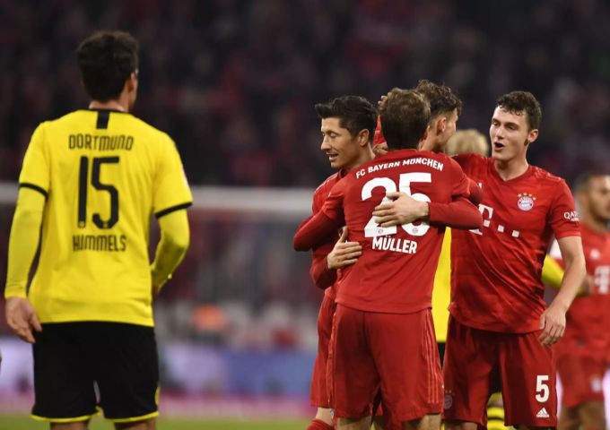 Spieler von Bayern München jubeln. Mats Hummels vom BVB schaut zu. BVB Bayern