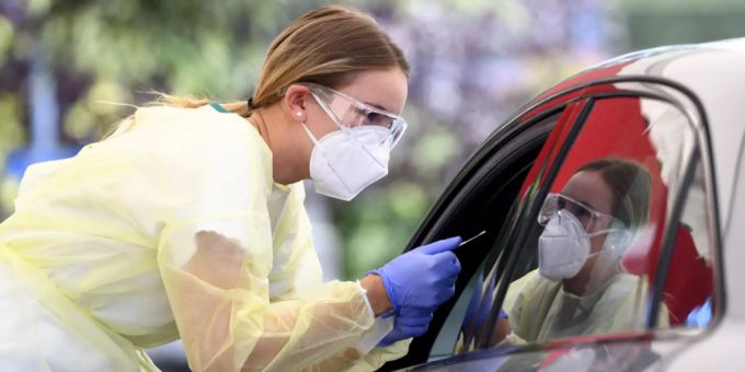 Eine Mitarbeiterin eines Drive-In-Testzentrums führt einen Test auf das Coronavirus durch. Coronavirus Test