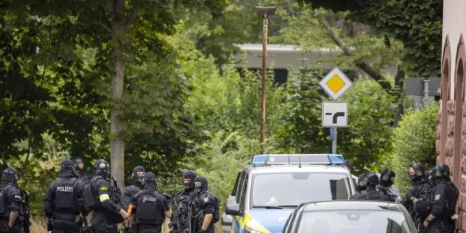 Schwer bewaffnete Polizisten sichern eine Strasse in Frankfurt. Foto: Helmut Fricke/DPA/dpa Schwer bewaffnete Polizisten sichern eine Strasse in Frankfurt. Foto: Helmut Fricke/DPA/dpa