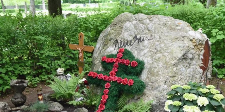 Ein Lothringer Kreuz aus roten Rosen und ein grosser Felsbrocken schmücken das Grab des französischen Schauspielers Pierre Brice. Foto: Ursula Düren/dpa