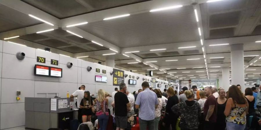 Gestrandete Urlauber stehen in einer Schlange am Flughafen von Palma de Mallorca. Foto: Isaac Buj/Europa Press