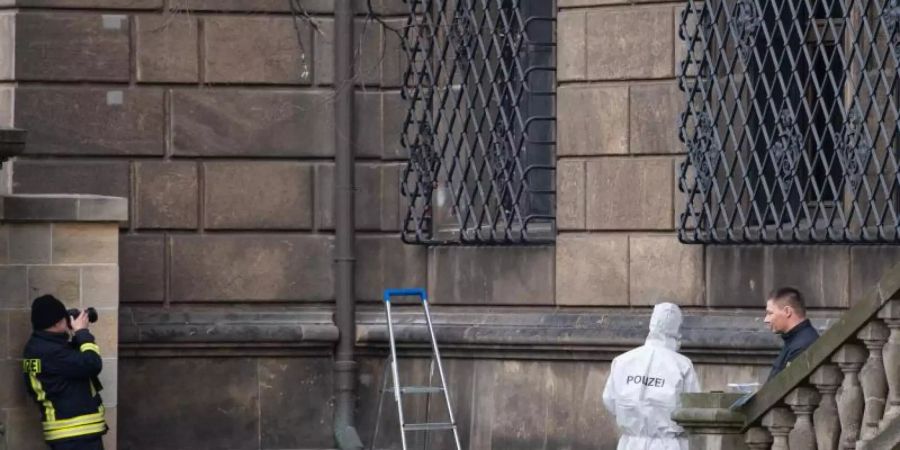 Einsatzkräfte neben dem durchtrennten Gitterfenster des Grünen Gewölbes am Residenzschloss in Dresden. Foto: Sebastian Kahnert/zb/dpa