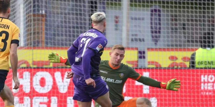 Osnabrücks Niklas Uwe Schmidt (M) erzielt den Treffer zum 2:0 gegen Florian Ballas (l) und Torwart Kevin Broll (r) aus Dresden. Foto: Friso Gentsch/dpa