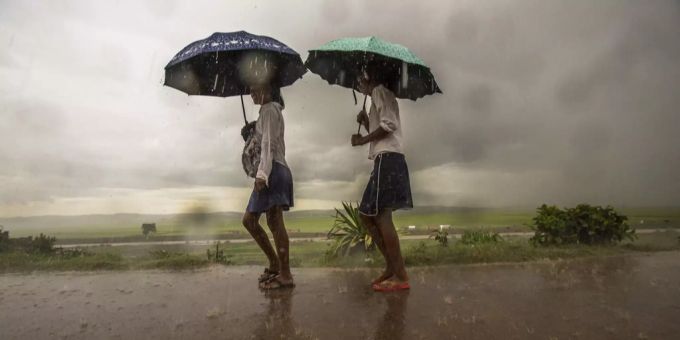 Schulmädchen machen sich bei starkem Regen in Antananarivo (MDG) auf den Weg. wirbelsturm