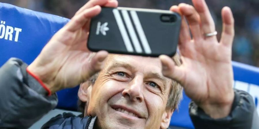 Hertha-Coach Jürgen Klinsmann und sein Smartphone. Foto: Andreas Gora/dpa