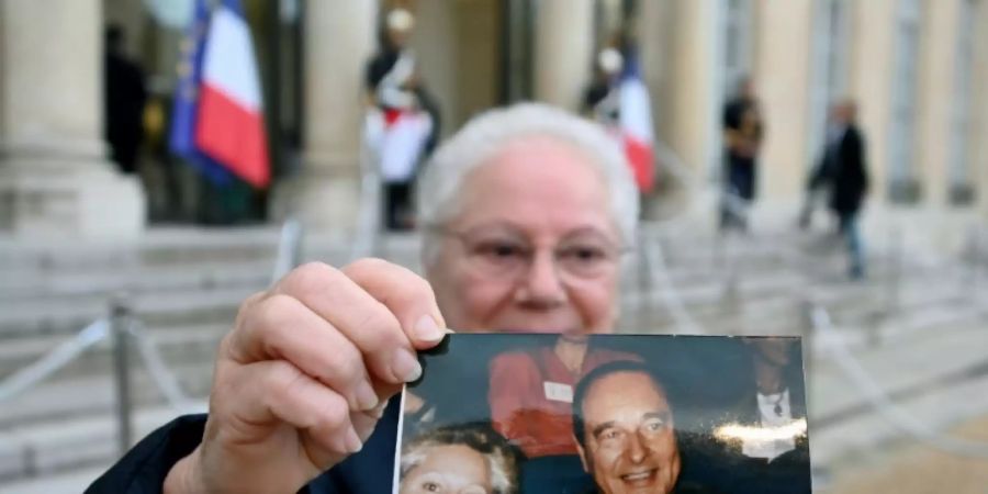 Ein Anhänger Chiracs mit einem Foto des Ex-Präsidenten im Elysée-Palast