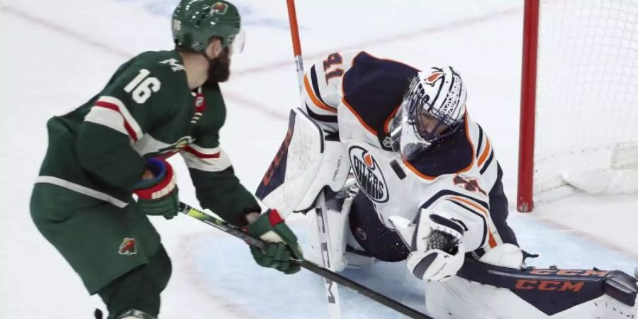 Jason Zucker (l) von den Minnesota Wild im Duell mit Oilers-Goalie Mike Smith. Foto: Stacy Bengs/AP/dpa