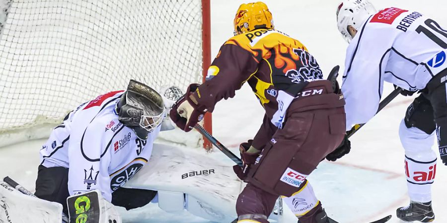 Luganos Goalie Sandro Zurkirchen hatte viel zu tun im Match gegen Genf-Servette. Hier muss er sich gegen Tommy Wingels wehren. Rechts Alessio Bertaggia