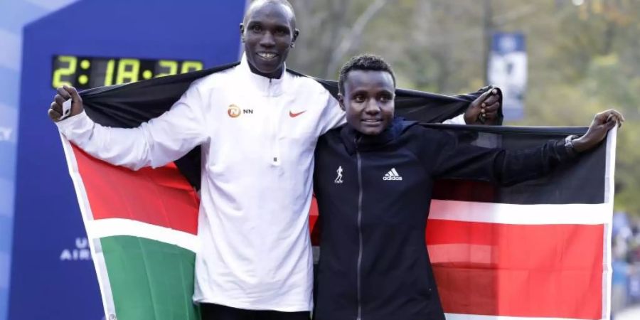 Die Kenianer Geoffrey Kamworor und Joyciline Jepkosgei posieren während der Siegerehrung mit den Landesfarben. Foto: Richard Drew/AP/dpa