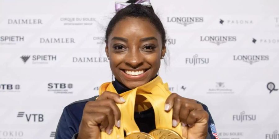 Simone Biles aus den USA posiert mit ihren fünf Goldmedaillen bei der WM. Foto: Marijan Murat/dpa