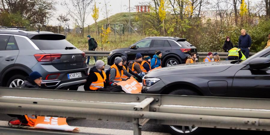 Teilnehmer eines Klimaprotests blockieren auf der A113 kurz vor der Ausfahrt zum Flughafen Berlin Brandenburg (BER) «Willy Brandt» den Verkehr.