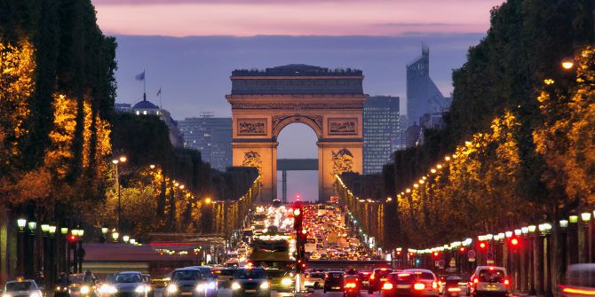 Die Champs Élysée und der Arc de Triumph in Paris im Abendverkehr.