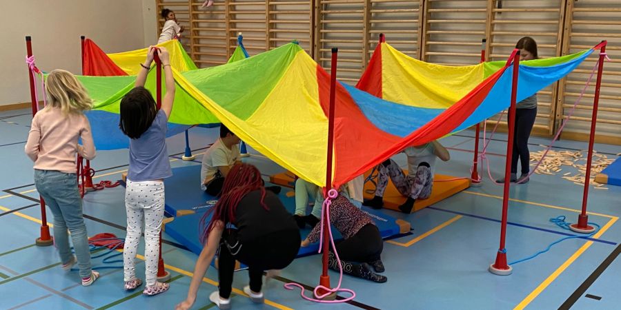 Kinder spielen in einer Turnhalle
