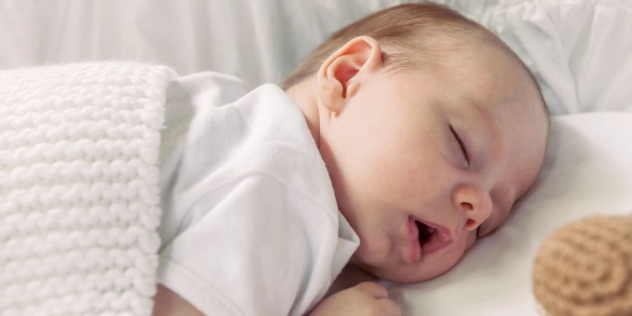 Lose Bettwäsche kann beim Bauchliegen eine Gefahr für Babys darstellen und sollte vermieden werden.