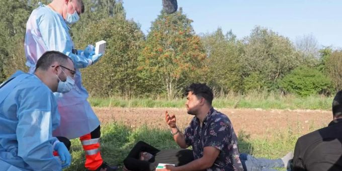 Sanitäter sprechen mit der Gruppe von Flüchtlingen an der polnisch-belarussischen Grenze. Foto: Artur Reszko/PAP/dpa Sanitäter sprechen mit der Gruppe von Flüchtlingen an der polnisch-belarussischen Grenze. Foto: Artur Reszko/PAP/dpa