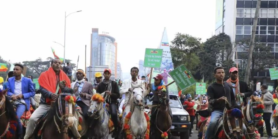 Demonstranten reiten durch Äthiopiens Hauptstadt Addis Abeba, um ihr Bekenntnis zur Unterstützung der nationalen Armee im Kampf gegen die Partei Volksbefreiungsfront von Tigray (TPLF) zu erneuern. Foto: Stringer/AP/dpa