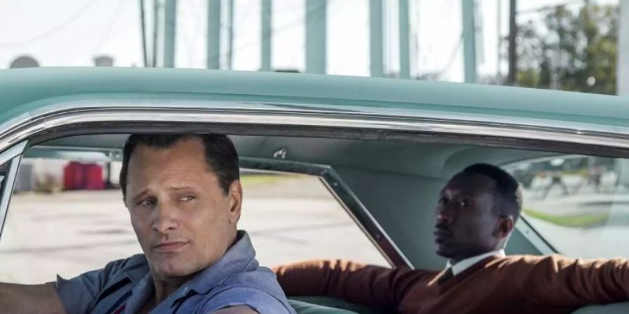 Der gefeierte Pianist Dr. Donald Shirley (Mahershala Ali, r) lässt sich vom Nachtklub-Türsteher Tony (Viggo Mortensen, l) im Cadillac DeVille chauffieren. Foto: --/ARD Degeto/Universal Studios/dpa