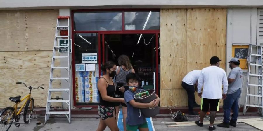 In Tulum wird ein Geschäft mit Brettern vernagelt. Foto: Marco Ugarte/AP/dpa