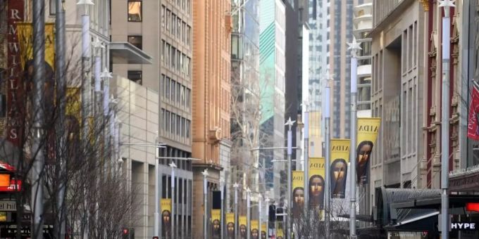 Passanten gehen über eine fast menschenleere Strasse im Geschäfts- und Einkaufsviertel von Sydney. Foto: Dan Himbrechts/AAP/dpa Passanten gehen über eine fast menschenleere Strasse im Geschäfts- und Einkaufsviertel von Sydney. Foto: Dan Himbrechts/AAP/dpa