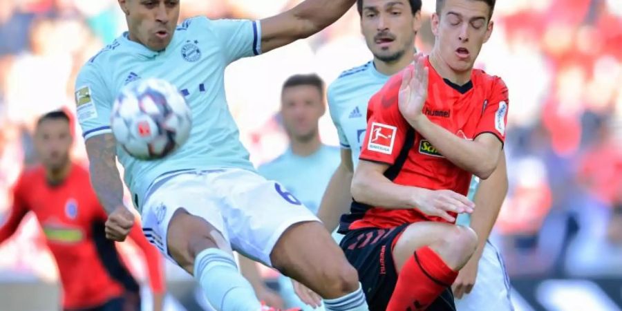 Münchens Thiago (l) und Freiburgs Janik Haberer im Zweikampf um den Ball. Foto: Uwe Anspach/dpa