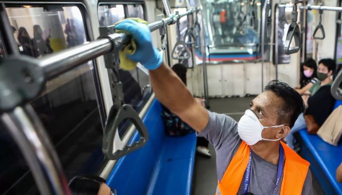 Ein Arbeiter desinfiziert einen Wagen der Metro Rail Transit-3. Coronavirus - Philippinen