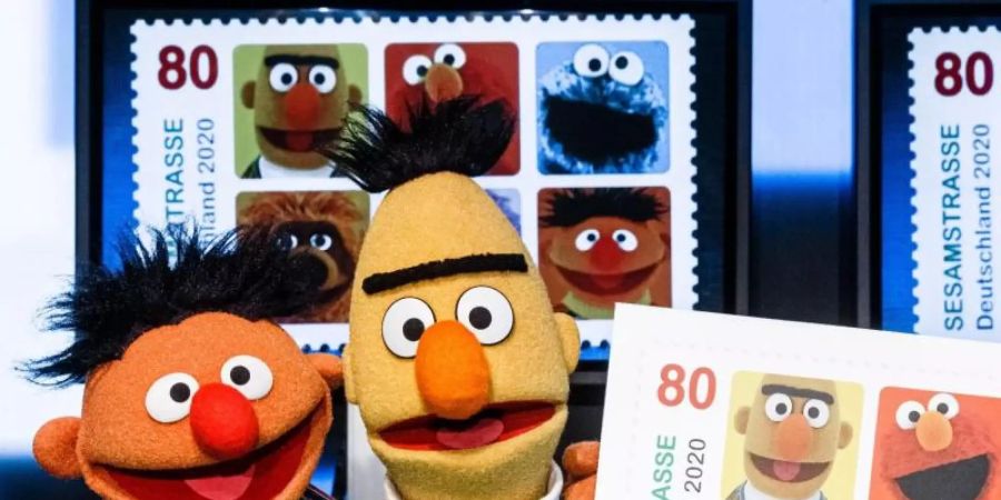 Ernie und Bert präsentieren die Sonderbriefmarke. Foto: Markus Scholz/dpa