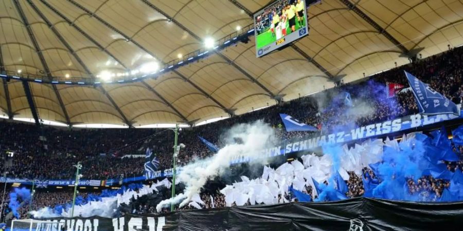 HSV-Fans brennen vor dem Spiel gegen den KSC Pyrotechnik ab. Foto: Daniel Bockwoldt/dpa