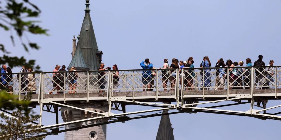 Touristen stehen auf der Marienbrücke vor dem Schloss Neuschwanstein.