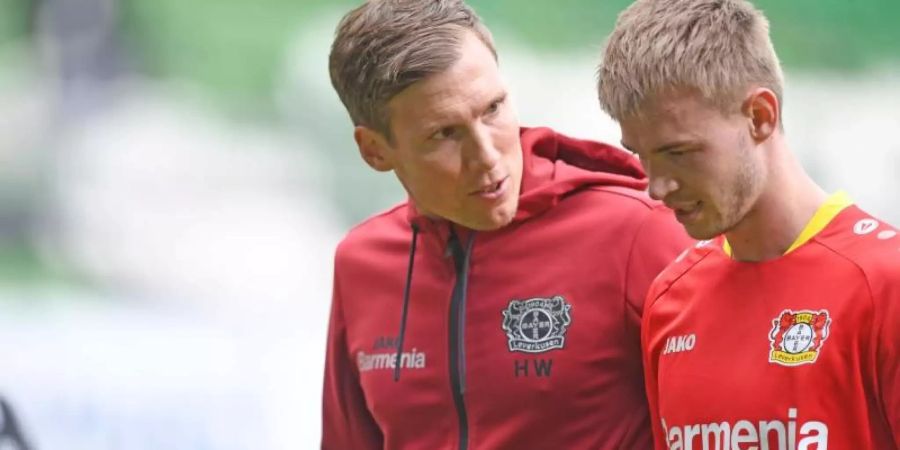 Leverkusens Trainer Hannes Wolf (l) spricht mit Daley Sinkgraven auf dem Weg in die Halbzeit. Foto: Carmen Jaspersen/dpa