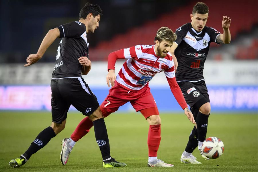 Luca Clemenza (m.) vom Sion wird gleich von zwei Lugano-Spielern angegriffen.