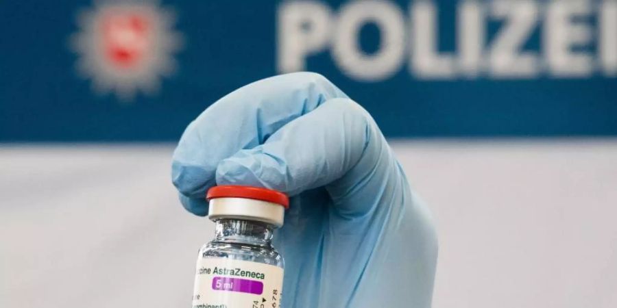 Eine Ärztin zeigt eine Ampulle mit dem Impfstoff Astrazeneca. Foto: Julian Stratenschulte/dpa