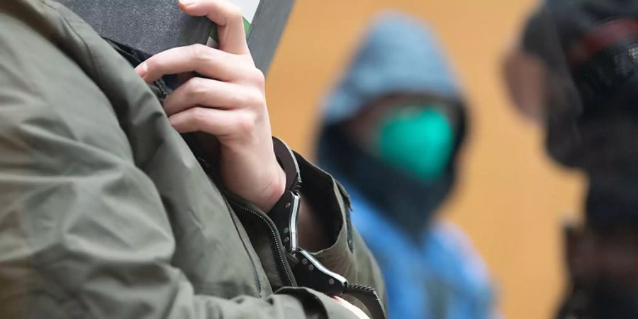 Zwei der Angeklagten sitzen kurz vor Beginn des Prozesses gegen die rechtsterroristische Vereinigung «Gruppe S.» in einem Saal im Oberlandesgericht Stuttgart-Stammheim. Foto: -/dpa-pool/dpa - ACHTUNG: Person(en) wurde(n) aus rechtlichen Gründen gepixelt