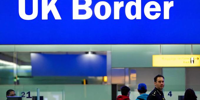 ARCHIV - Grenzbeamte stehen am Flughafen Heathrow unter einem Schild mit der Aufschrift «UK Border» (Grenze des Vereinigten Königreiches). Foto: Andrew Cowie/EPA/dpa ARCHIV - Grenzbeamte stehen am Flughafen Heathrow unter einem Schild mit der Aufschrift «UK Border» (Grenze des Vereinigten Königreiches). Foto: Andrew Cowie/EPA/dpa