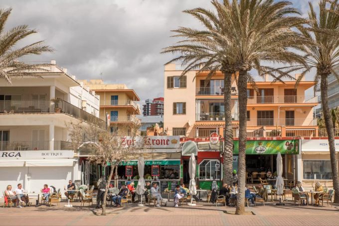 22.03.2021, Spanien, Berlin: Deutsche Touristen sitzen in der bekannten Bar Zur Krone & Krone Stube und geniessen einen Drink in der Sonne an der Playa de Palma auf Mallorca. Coronavirus - Mallorca