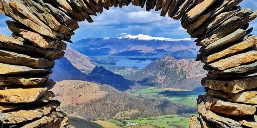 Durch ein kreisförmiges Steinkunstwerk ist das Borrowdale-Tal im Lake District zu sehen. Es stammt von einem Unbekannten. Foto: --/PA Media/dpa
