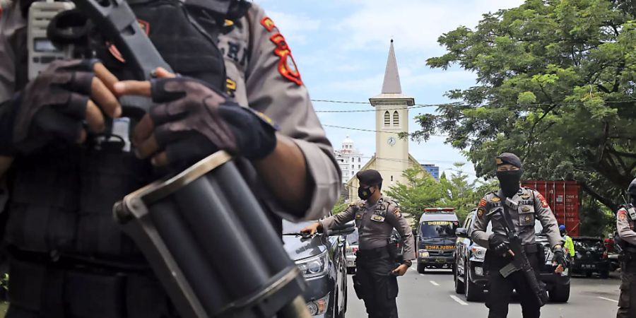 Polizisten stehen in der Nähe einer Kirche, in der es eine Explosion gab. Foto: Yusuf Wahil/AP/dpa